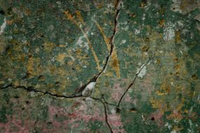 Close-up image of a cracked and moldy home foundation