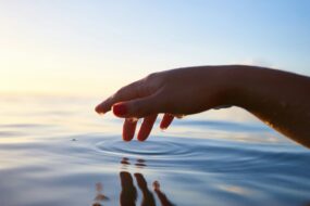 Hand hovering over a body of water