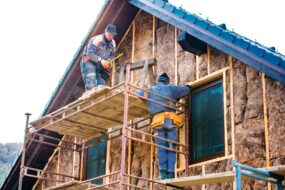 Image of insulation being installed on the upper floor of a residential building