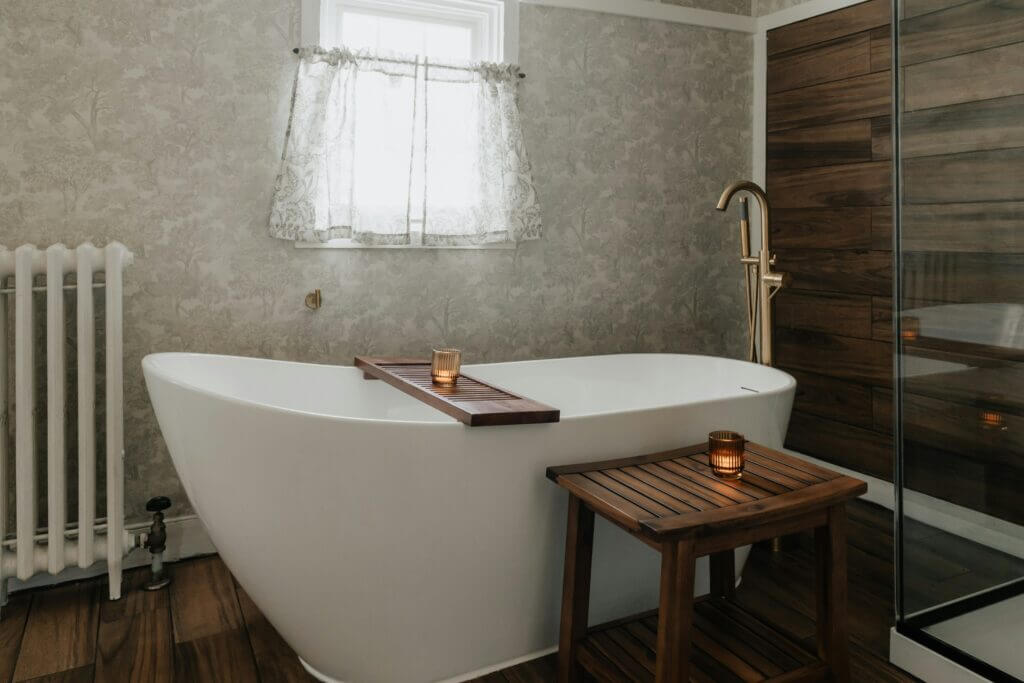 Picture of a deep soaking tub in a slipper style in a bathroom under a small window.