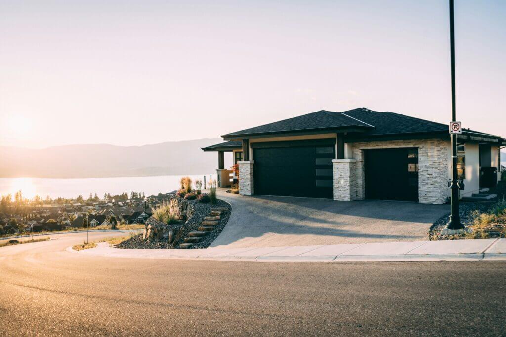 Black 3-car garage on a modern, corner-lot home