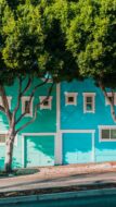 Blue and green garages on matching homes on a hill