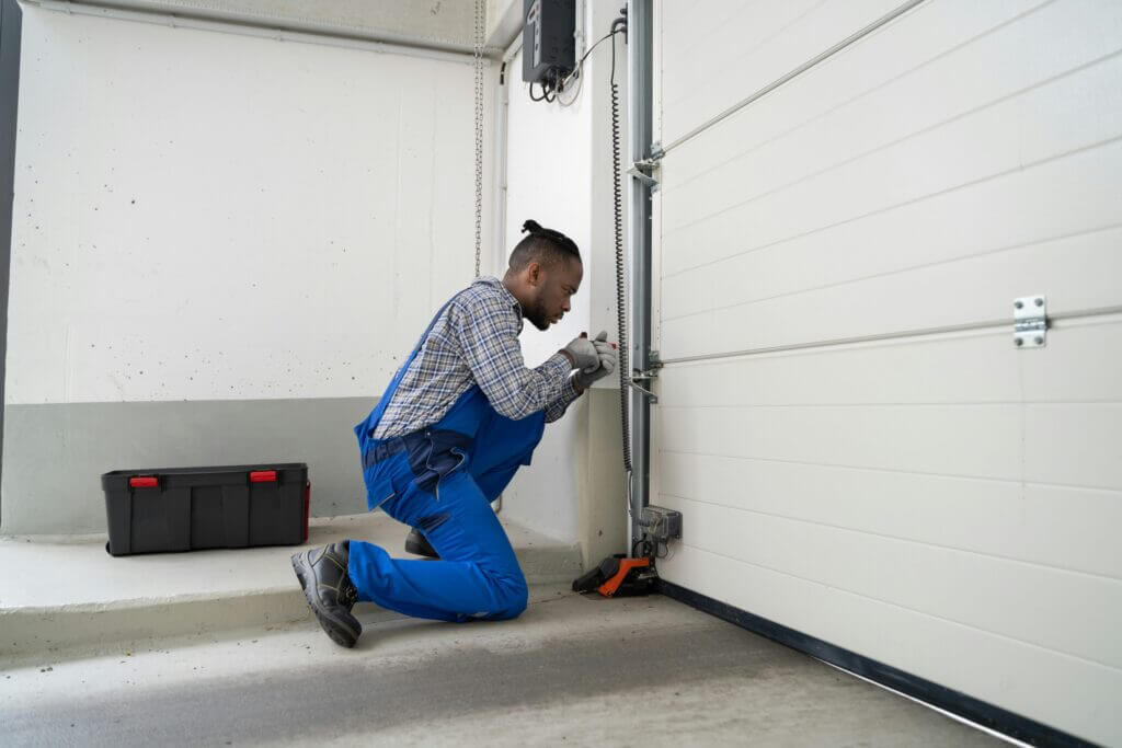 Contractor repairing a garage door track