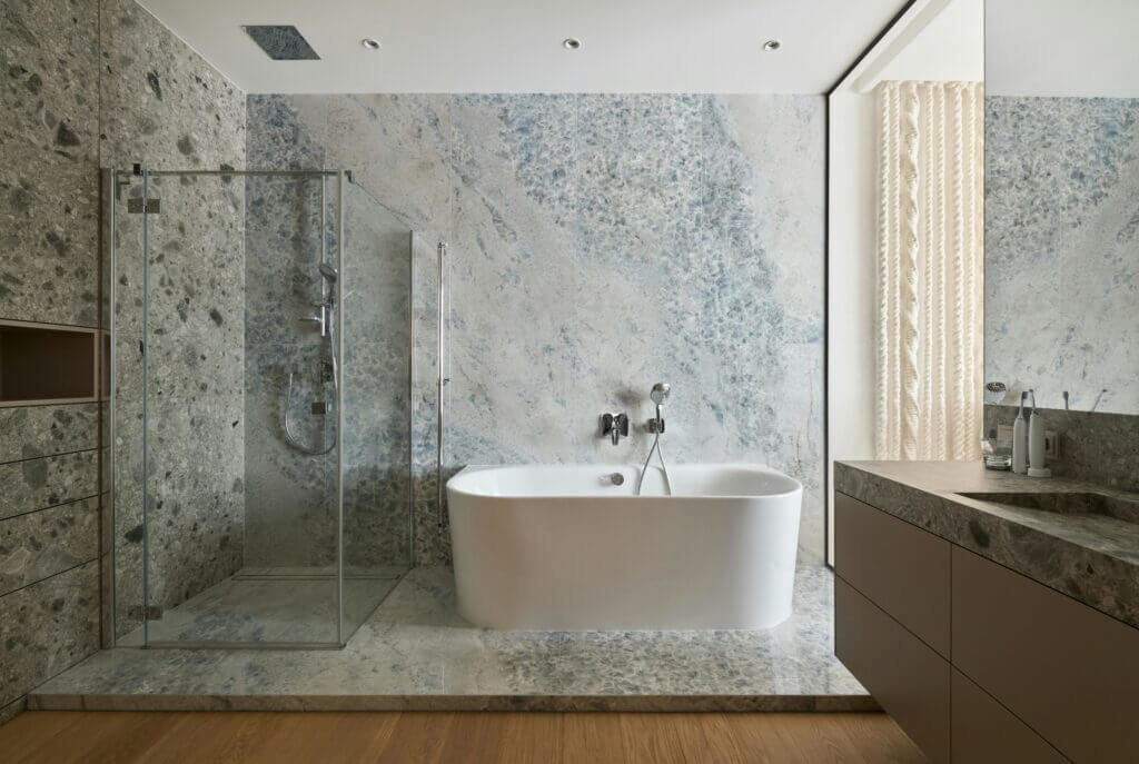 A picture of an updated bathroom with a tile platform that has a walk in shower and a soaking tub