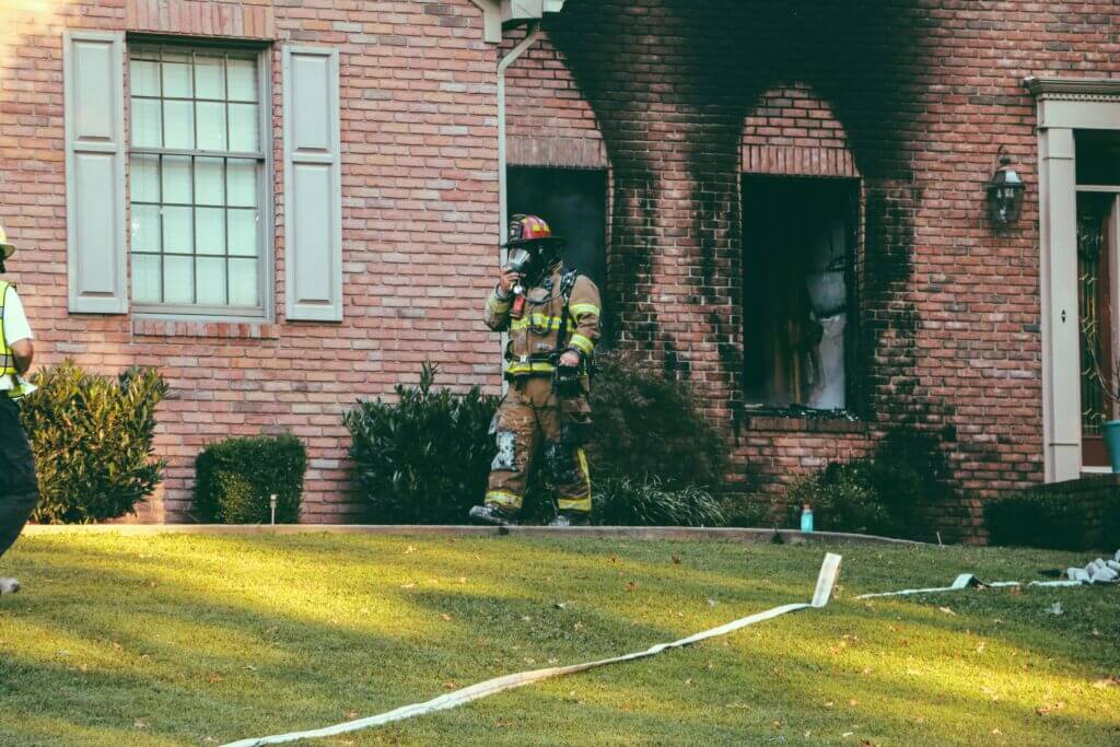 Brick home exterior with smoke and soot damage after the fire is out