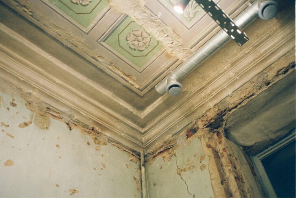 Image of corner of wall and ceiling with damage and mold growth