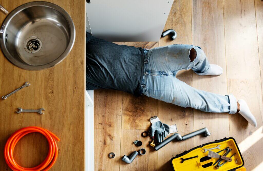 Plumber working under the sink