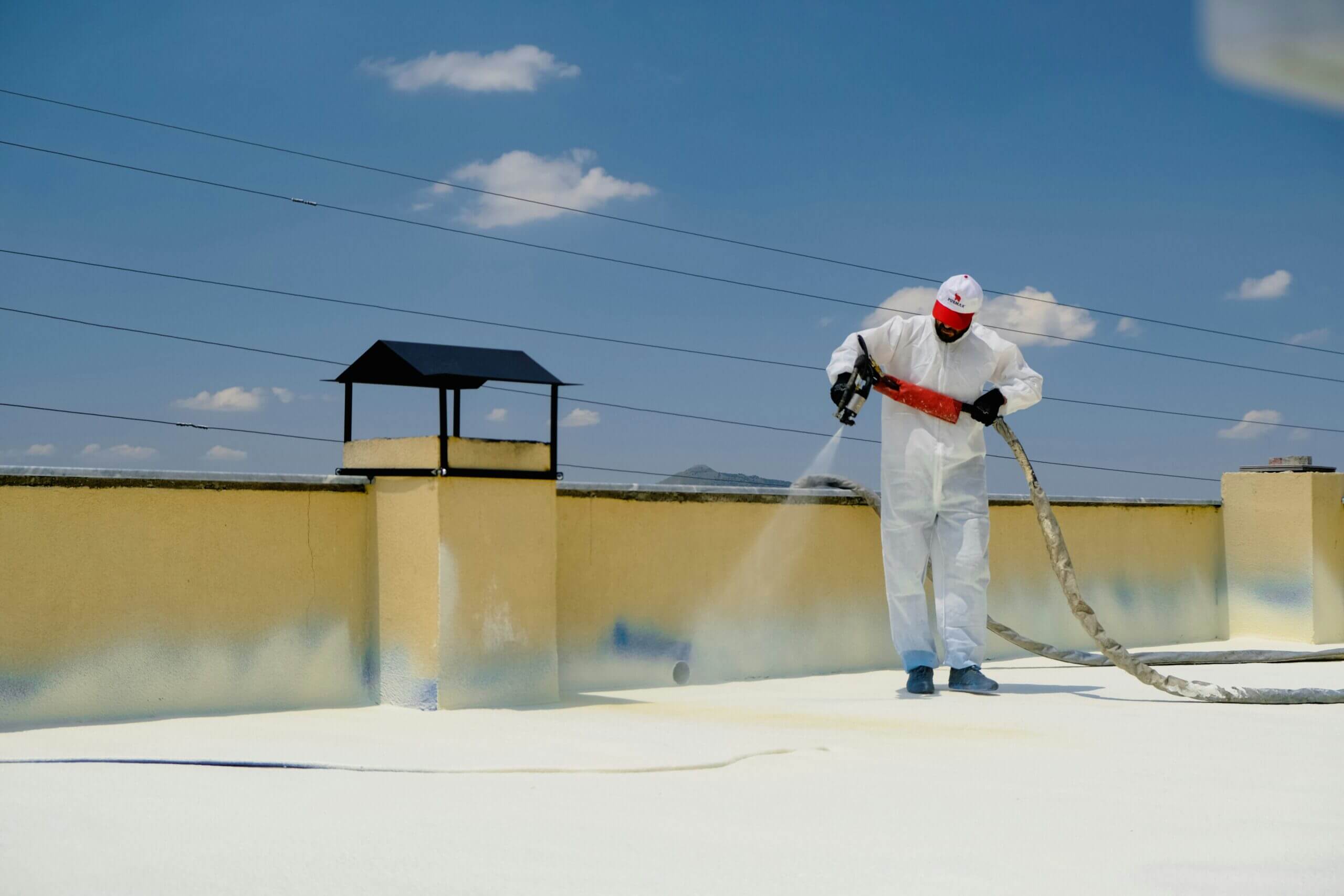 Man spraying a roof with UV coating