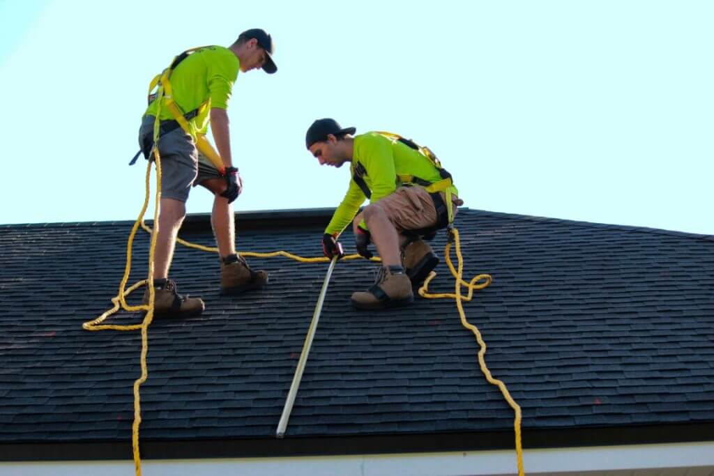 Two men on a roof in safety gear