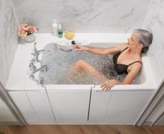 Woman reclining in a hydrotherapy walk-in tub by Kohler