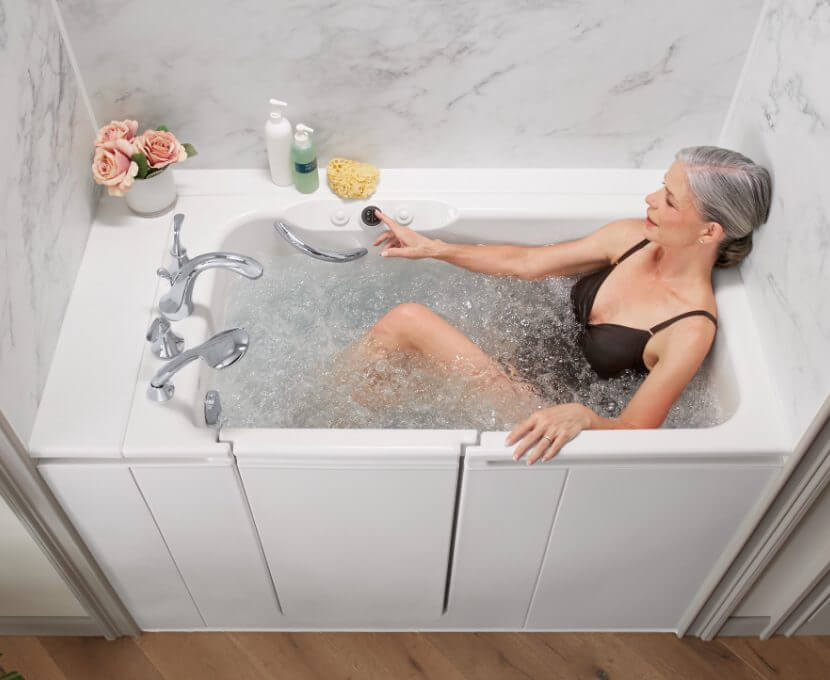 Woman reclining in a hydrotherapy walk-in tub by Kohler