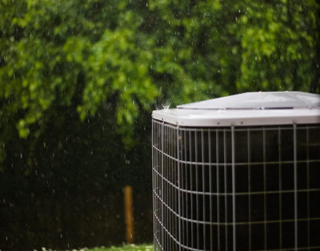 Picture of an HVAC condenser in the rain