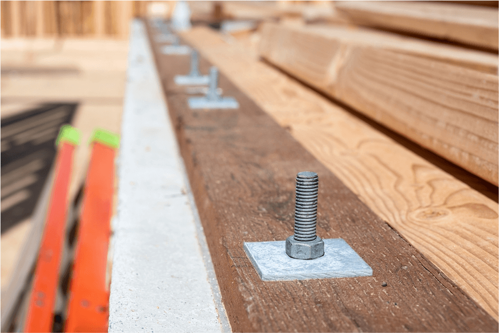 Sill plate with anchor bolts on top of a new concrete foundation wall