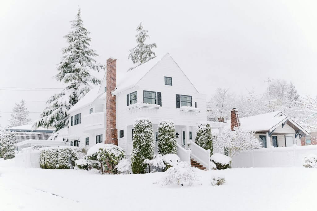 Photo of a white house surrounded by snow