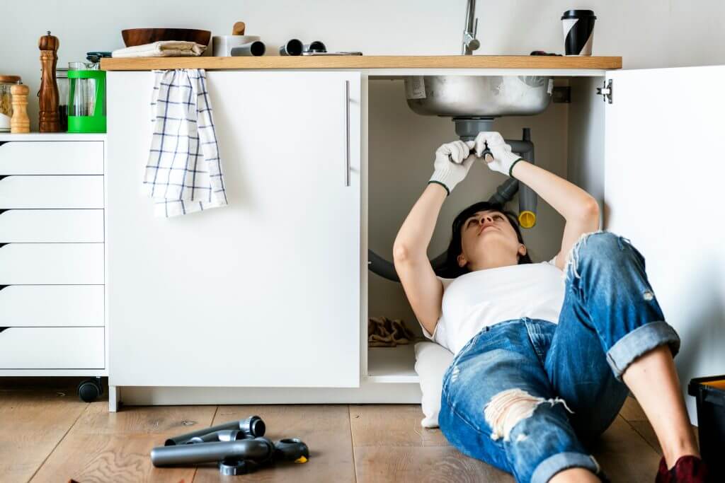 Plumber under sink doing repair