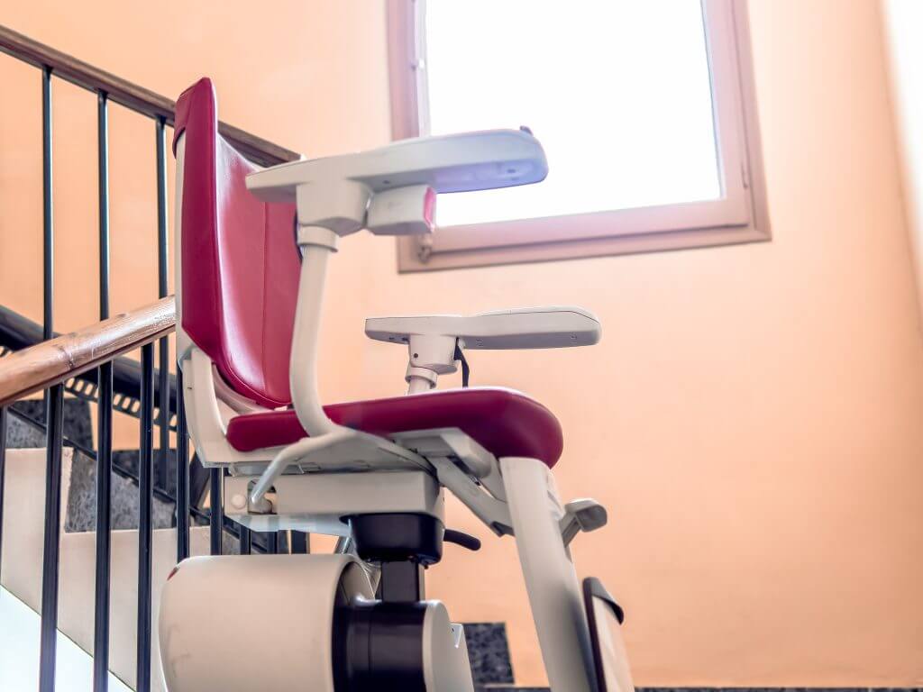 An unoccupied stairlift on an indoor staircase, illustrating accessible solutions for people with mobility challenges in multi-story buildings.