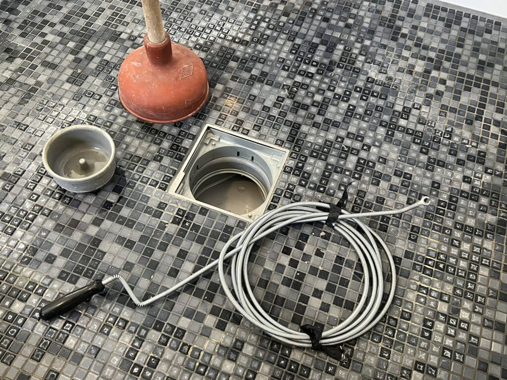 Cleaning a clogged pipe in a shower