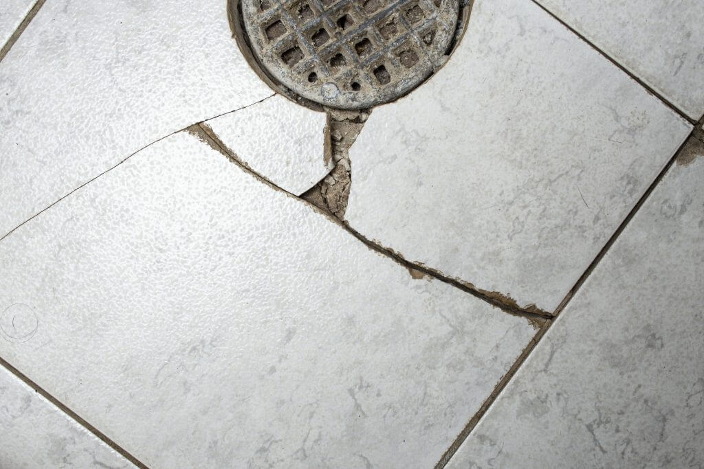 Clogged floor drain with broken ceramic tiles