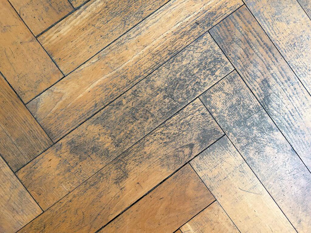 background of old damaged  herringbone  parquet in detail