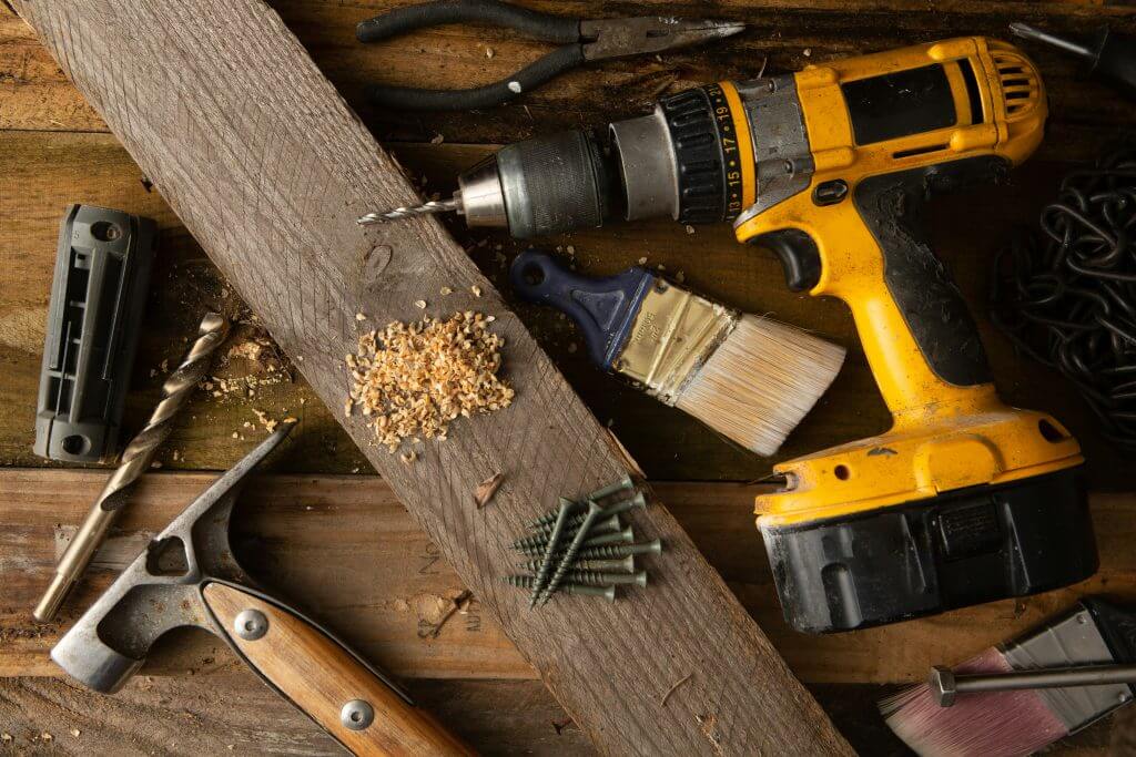 Photo of common home improvement tools on a wooden surface