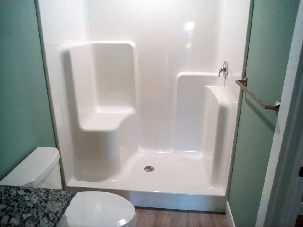 Acrylic walk-in shower with a built in bench and shelves