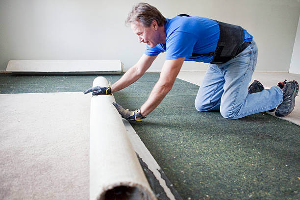 Man removing carpet during home renovations.