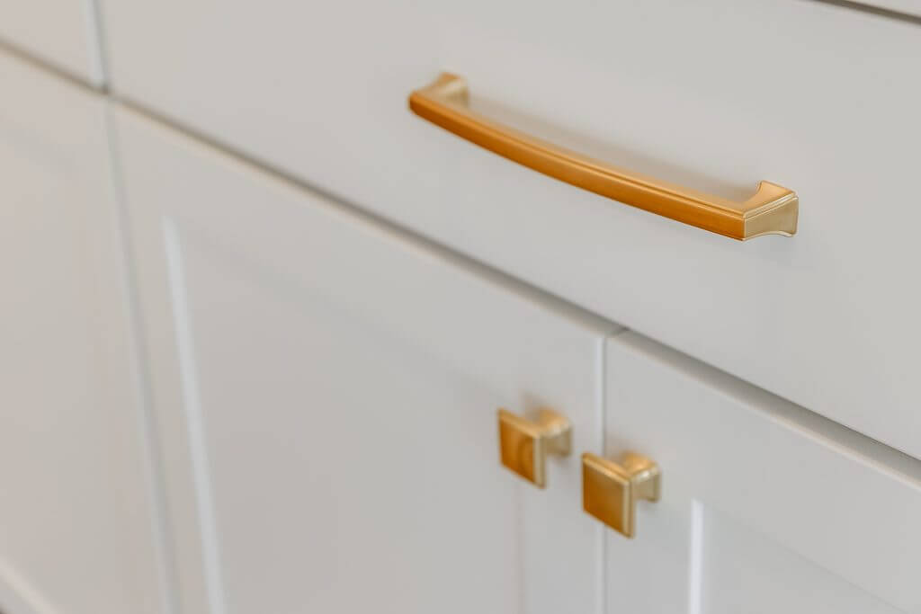 Brushed brass drawer and cabinet hardware in a kitchen