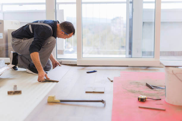 Handyman working on a new parquette floor at an apartment