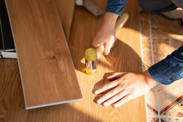 Carpenter is working on SPC flooring inside the house.