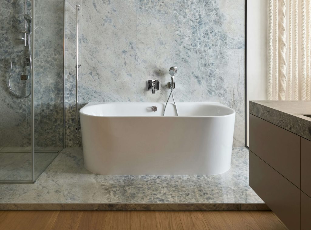 A picture of an updated bathroom with a tile platform that has a walk in shower and a soaking tub